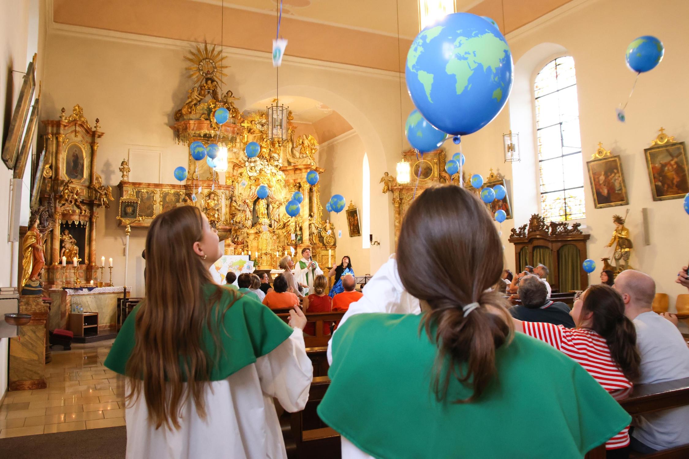 Luftballons steigen zur Kirchendecke hinauf.