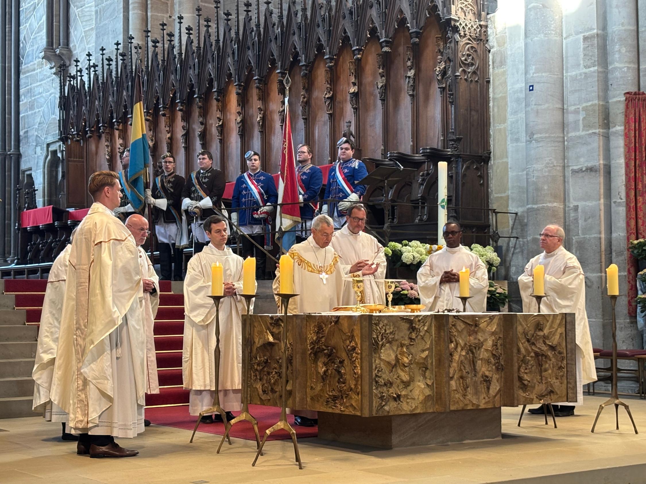 Acht Priester stehen inklusive Bischof Schick um den Altar